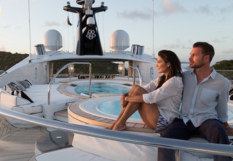 charter guests relax near the Jacuzzi on the sundeck of superyacht PHOENIX 2