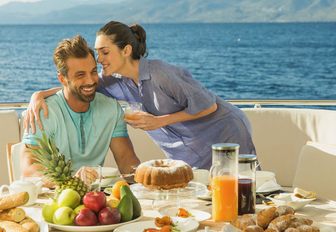 guests have breakfast on the al fresco dining area aboard charter yacht THEORIS 