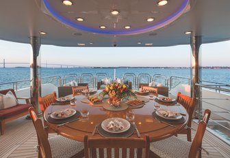 round al fresco dining table on the upper deck aft of motor yacht Far From It 