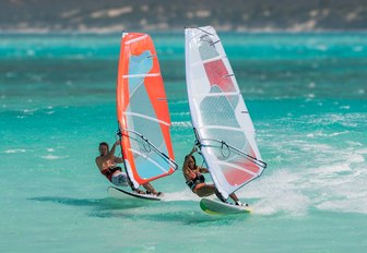 Two people windsurfing next to each other