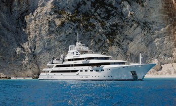 Charter yacht EMIR at anchor in front of a towering cliff