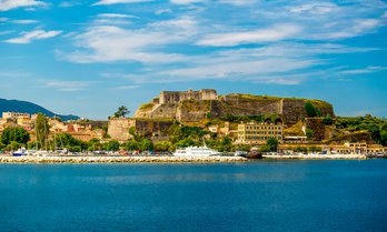 Distant view of the Port of Corfu with a superyacht charter berthed