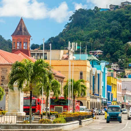 Overview of a street in the Caribbean with multicolored buildings and palm trees