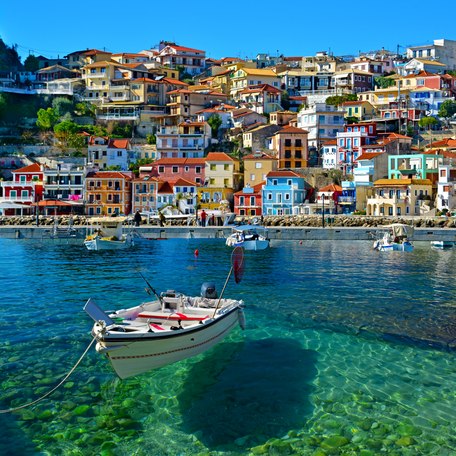 Water-level view of a single fishing boat at anchor in front of a Greek island