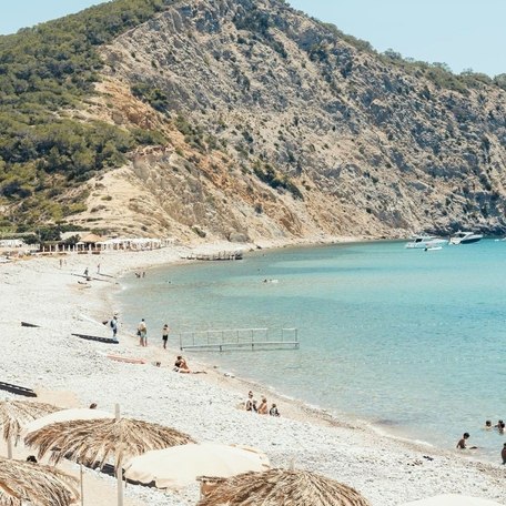 Visitors enjoying the sun and clear waters from Cala Jondal's golden beach