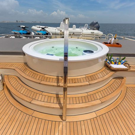 On-deck Jacuzzi on charter yacht ARIADNE, with sunpads either side, surrounded by sea.