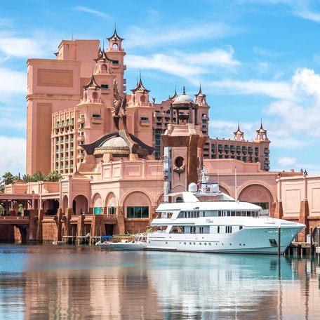 Water-level view of the Atlantis hotel in the Bahamas, with a motor yacht charter berthed in front