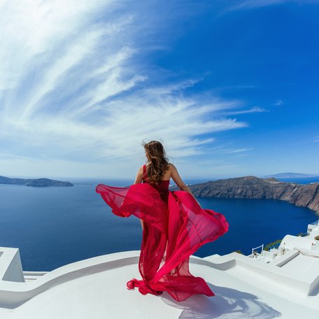 A female charter guest in a red dress in Santorini