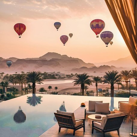Hot air balloons floating over the mountainous Oman landscape