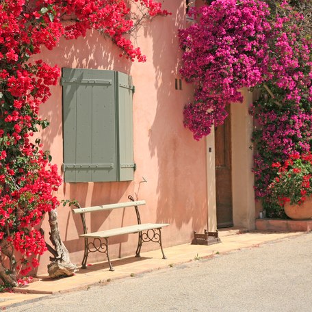 A pink building with pink and red florals on the wall in France