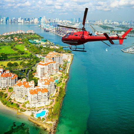 A red helicopter flying over Miami
