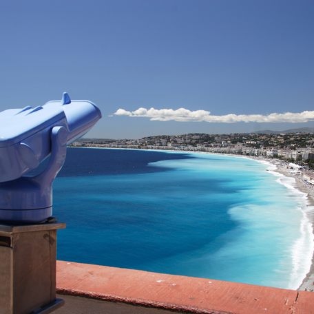 A blue telescope overlooking the coastline of Nice