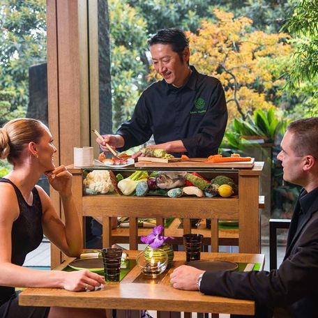 Yoshi chef preparing food at a table with charter guests watching