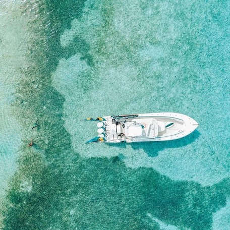 Aerial shot of small boat on turquoise water 