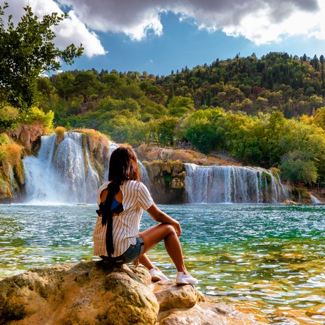 A female charter guest sat watching a waterfall 