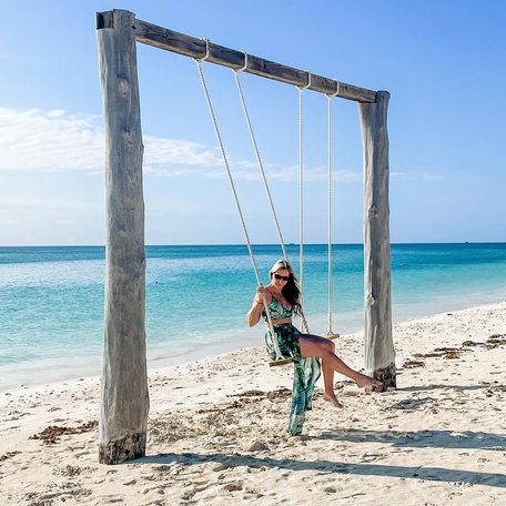 Woman sat posing on swing seat in Grand Bahama