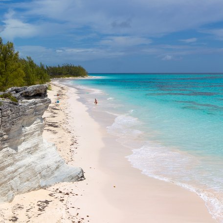 A deserted beach in the Bahamas with the sea on the right.