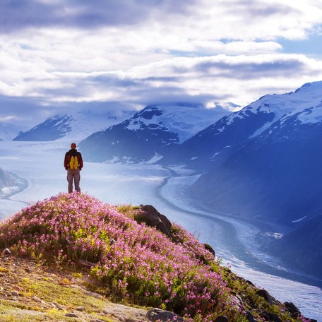 A charter guest standing on a mountain peak overlooking the view