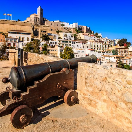 A cannon perched on a wall overlooking the Ibiza coastline