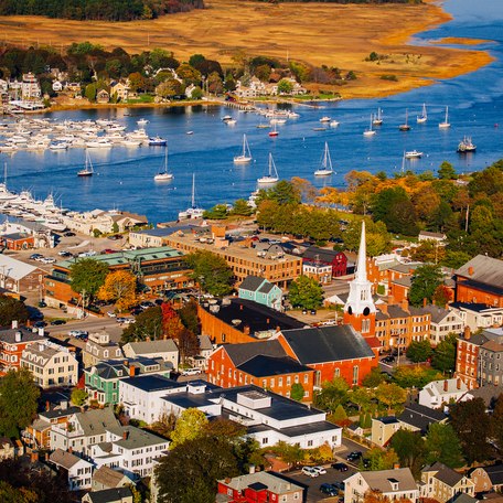 Arial view of a New England town in the Fall with a church and steeple in the foreground