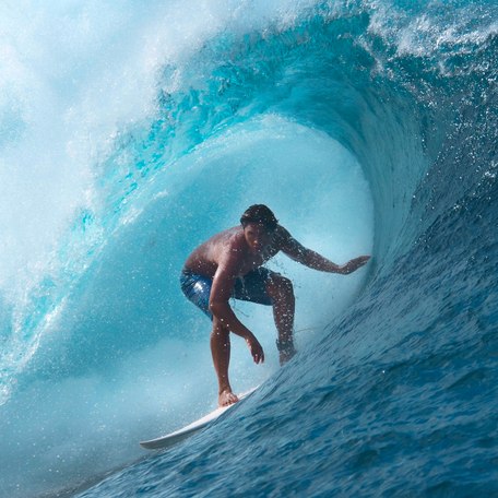 A male charter guest surfing 