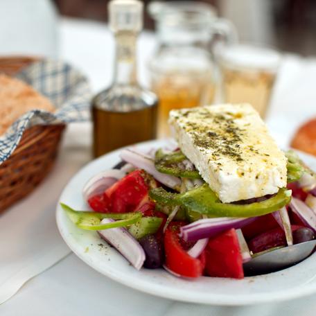 A dish of Mediterranean food with feta and olive oil in the background