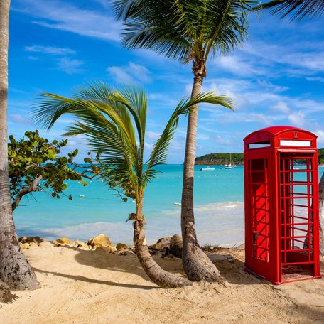 A red British phone box on a beach in the British Virgin Islands.