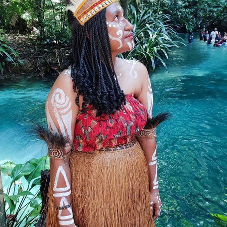 Woman in traditional indigenous dress by the river 
