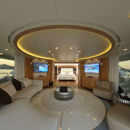 Lounge area onboard charter yacht GRANDE AMORE, white sofa to port facing armchairs and wide window. 