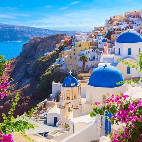 Santorini island, Greece. Oia town traditional white houses and churches with blue domes over the Caldera, Aegean sea