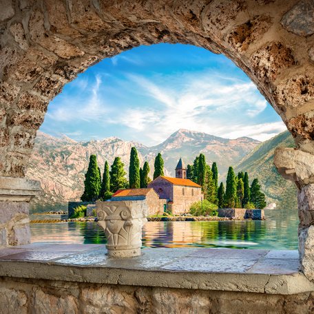 Scenery in Montenegro, quaint building visible through stone archway