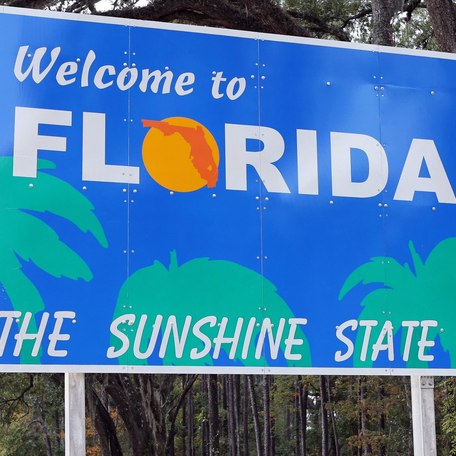 Road sign reading Welcome to Florida, the sunshine state