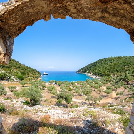 A view of a Grecian bay, looking through an ancient stone arch