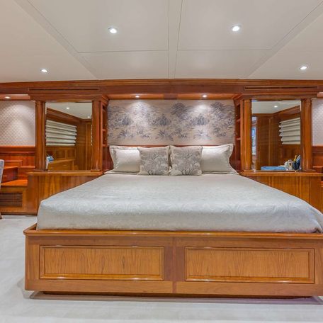 Master cabin onboard charter yacht ARIADNE, central berth facing forward with seating to starboard and a desk to port