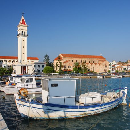 Overview of a Greek settlement with a tower watching over the marina of small boats