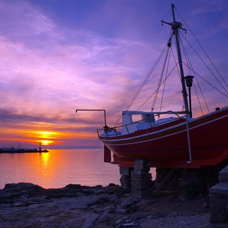 A boat sat on a beach at sunset on the island of Mykonos