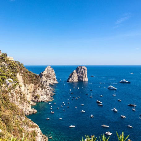 Elevated view of the coastline alongside Capri with multiple sailing yacht charters at anchor