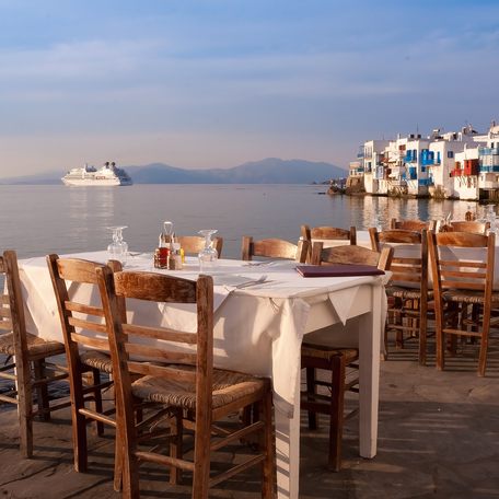 Arrangement of elegant dining tables on the water's edge in Mykonos