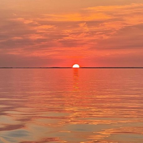 Glowing red sunset over Lynyard Cay's calm waters