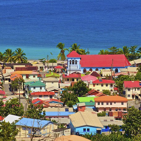 Overview of a city in St Lucia, many colored buildings with the sea in the background