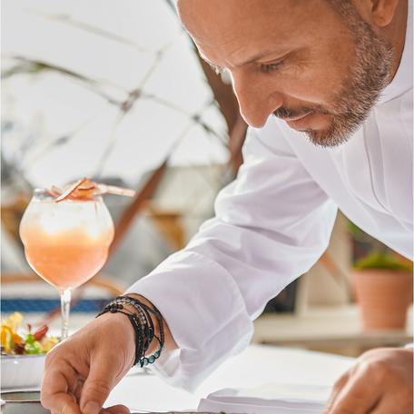 A chef finalizing a dish at Bagatelle St Tropez