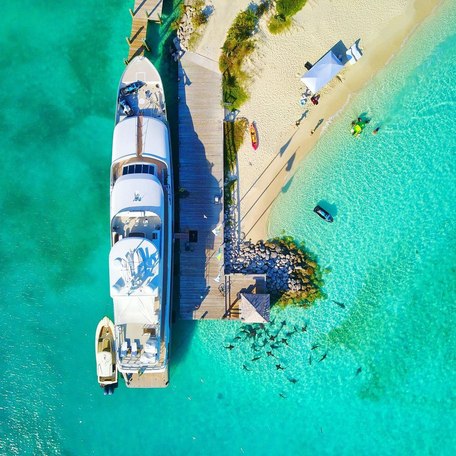 View of a yacht docked by a jetty from above 