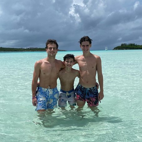 Three boys huddled for photo in crystal clear waters 