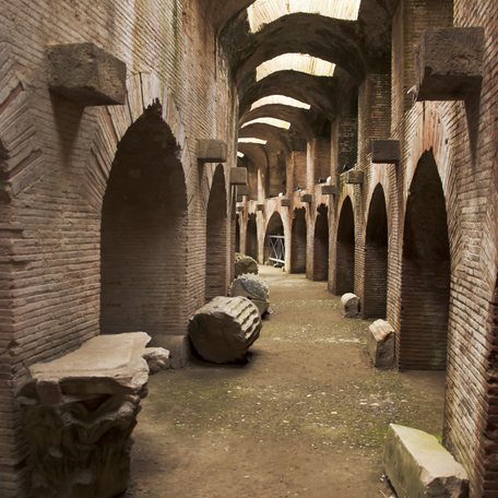 Ground view looking down a historic brick alleyway with arches to either side