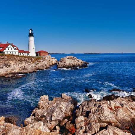 A lighthouse on the rocks on the coastline of New England