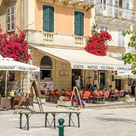 Overview of boutique shops and cafes lining a street in Greece