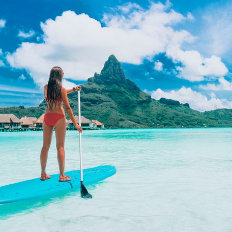 A female charter guest paddleboarding in French Polynesia