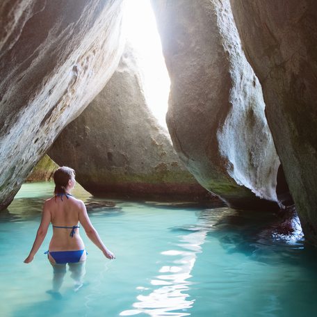 A charter guest wading through water in a cavern