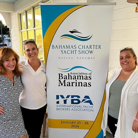 Crew standing with a poster reading Bahamas Charter Yacht Show
