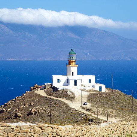 Overview of a white lighthouse overlooking the sea on the Greek island of Mykonos